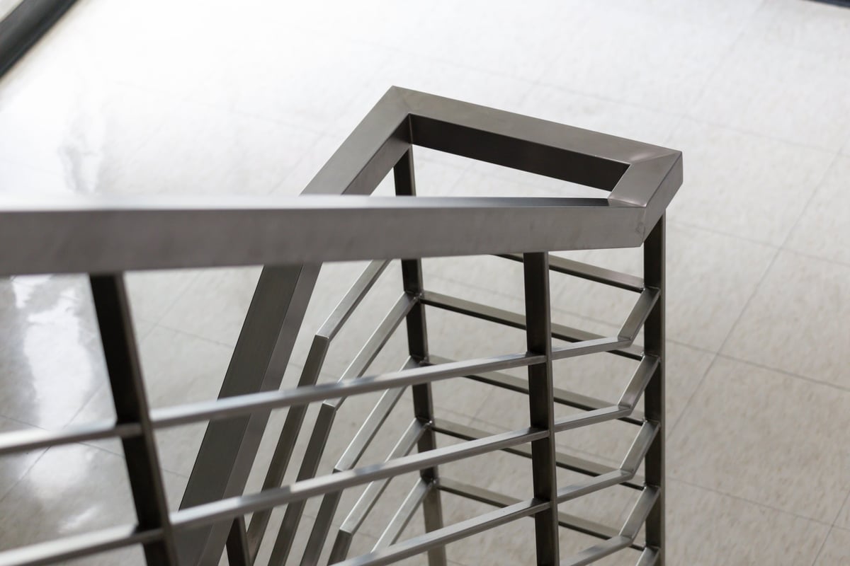 Modern metal staircase railing with sleek geometric design and reflective finish